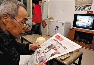 去年12月16日晚,呼格吉勒图的父亲李三仁在家中看新华每日电讯关于呼格案的整版报道。央视焦点访谈栏目刚好也在播放关于呼格案件的新闻。新京报记者 郭铁流 周岗峰 摄