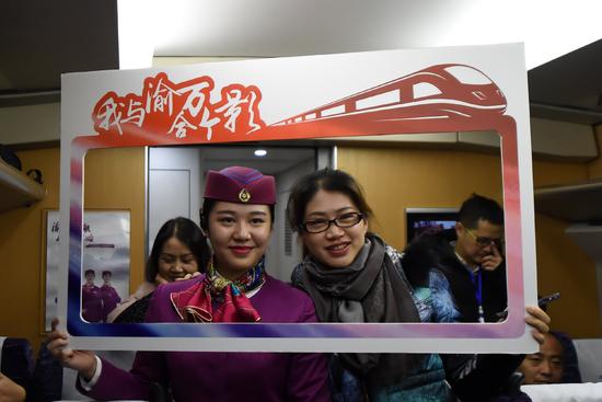 11月28日,一位乘客与列车工作人员在渝万城际高铁首发列车上合影留念。 11月28日,一位乘客与列车工作人员在渝万城际高铁首发列车上合影留念。