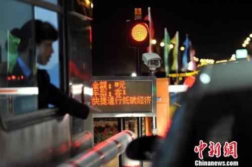 资料图：一辆小轿车免费通过江西高速公路一收费站口。刘占昆 摄