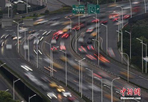 资料图：5月1日傍晚，大批车辆行驶在高速公路连接南京市区的高架道路上。 泱波 摄