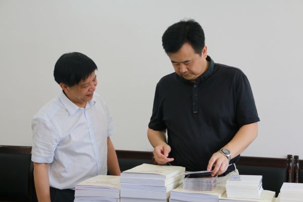 张勇强副州长在州民宗委主任廖于实的陪同正参阅民族团结进步创建工作资料