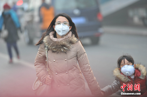 资料图。北京市民在雾霾中行走。 中新网记者 李泊静 摄