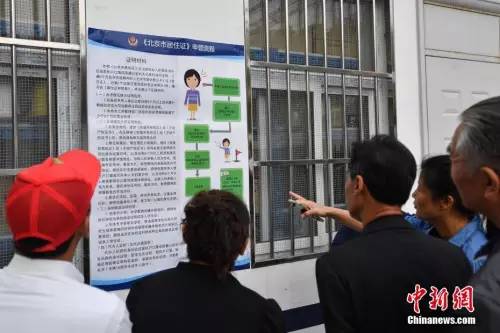 资料图:民众阅读办理居住证的相关要求细则。 <a target='_blank' href='http://www.chinanews.com/'>中新社</a>记者 崔楠 摄