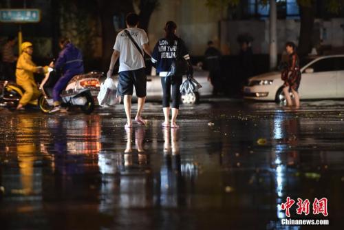 资料图：汛期北京积水路段上的行人。<a target='_blank' href='http://www.chinanews.com/' >中新网</a>记者 金硕 摄