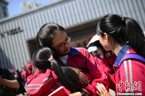 资料图：内蒙古高中生毕业典礼 同学拥抱惜别。<a target='_blank' href='http://www.chinanews.com/'>中新社</a>记者 刘文华 摄