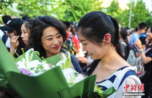 资料图：山东济南众多考生手捧鲜花在家长的簇拥下欢快告别高考。<a target='_blank' href='http://www.chinanews.com/'>中新社</a>记者 张勇 摄