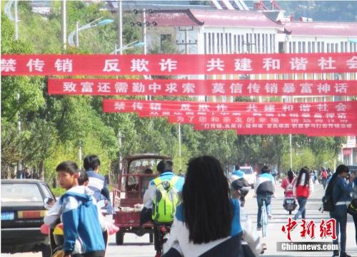 资料图：2015年10月13日，安徽安庆岳西街头拉起众多条幅开展禁止传销宣传。吴均奇 摄 图片来源：CFP视觉中国