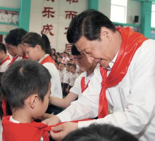 　　2014年5月30日，习近平来到北京市海淀区民族小学参加庆祝“六一”国际儿童节活动。这是习近平在少先队入队仪式上，为新少先队员系上红领巾 鞠鹏摄 本刊