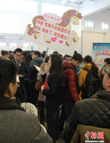 图为郑州一女生“举马”高调求职在熙熙攘攘人流中颇为醒目 蔡迅翔 摄