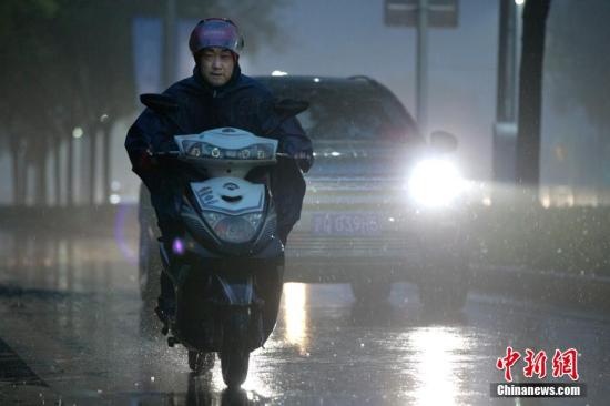 北京市民在雨中前行。 <a target='_blank' href='http://www.chinanews.com/'>中新社</a>记者 刘关关 摄