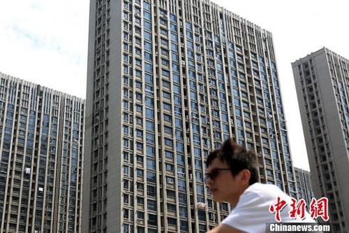 资料图：市民从南京一处楼盘前经过。<a target='_blank' href='http://www.chinanews.com/'>中新社</a>记者 泱波 摄