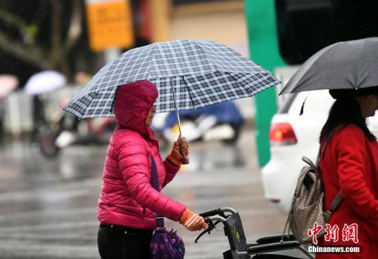 10月23日，昆明市区里身着羽绒服冒雨赶路的民众。霜降节气，昆明迎来降雨又降温的天气，气温降到8℃。霜降是24个节气里，秋季的最后一个节气，从此天气开始渐冷。 <a target='_blank' href='http://www.chinanews.com/'>中新社</a>记者 李进红 摄