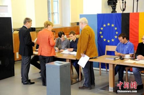 资料图：2017年9月24日，默克尔与丈夫绍尔在柏林洪堡大学的投票站参加大选投票。