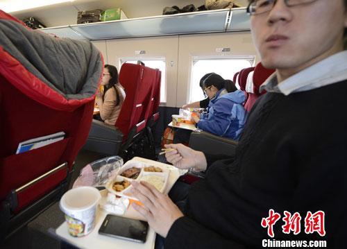 资料图：图为动车组乘客在品尝列车提供的餐食。<a target='_blank' href='http://www.chinanews.com/'>中新社</a>发 侯宇 摄