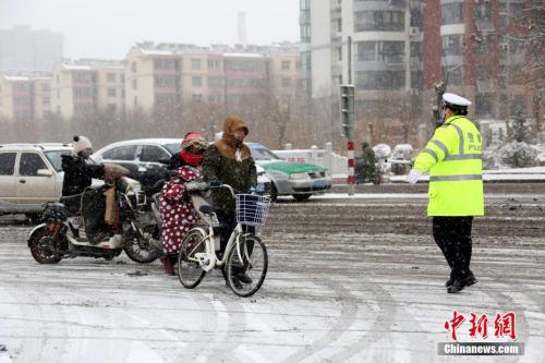 1月4日，山东省枣庄市公安局市中分局交通警察大队民警在当地的西外环路上冒雪指挥交通。 <a target='_blank' href='http://www.chinanews.com/'>中新社</a>发 吉 喆 摄 图片来源：CNSPHOTO