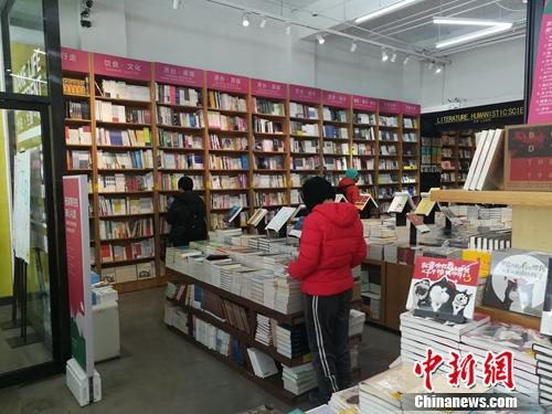 北京言几又书店(中关村店)内，读者正在翻看摆放的书籍。上官云 摄