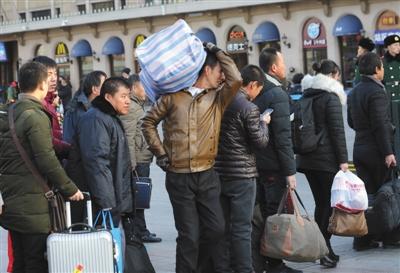 　昨日，北京站，乘客背着行李准备进站乘车。本版摄影/新京报记者 王贵彬 朱骏 实习生 陈婉婷