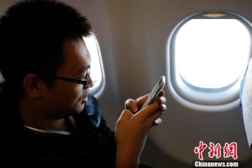 资料图：在东航MU5137航班上，旅客全程在飞行模式下可以使用手机。殷立勤 摄