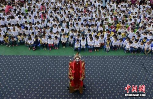 资料图：京剧进幼儿园，“财神”为孩子们表演下腰。 杨华峰 摄