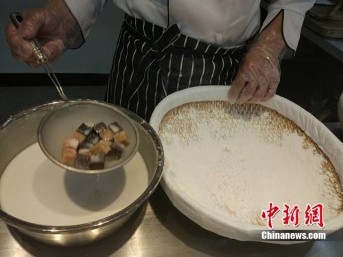 制作元宵时，首先要将馅料做好，沾上水，再投进盛满糯米粉的笸箩内摇。<a target='_blank' href='http://www.chinanews.com/' >中新网</a> 李金磊 摄