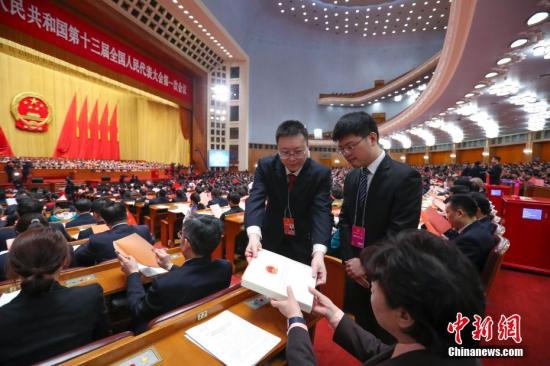 3月17日，十三届全国人大一次会议在北京人民大会堂举行第五次全体会议，选举产生新一届国家领导人。图为工作人员发放选票。<a target='_blank' href='http://www.chinanews.com/'>中新社</a>记者 刘震 摄