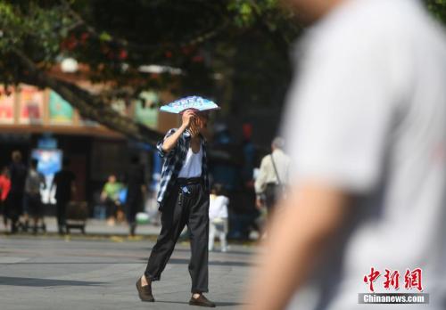 5月16日，杨家坪步行街上不少市民在高温中出行。当日，重庆市主城区气温飙升，室外温度已经超过35℃，提前进入了“烘烤”模式。陈超 摄