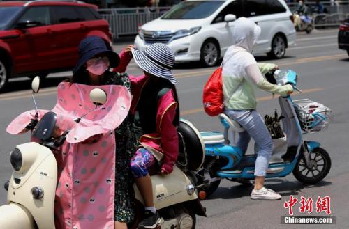 资料图：6月6日，河南郑州遭遇高温天气，出行民众“全副武装”遮阳防晒。<a target='_blank' href='http://www.chinanews.com/'>中新社</a>记者 王中举 摄