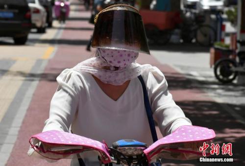 资料图：6月5日中午，河北石家庄户外温度达到38℃，市民出行携带各种遮阳护具。<a target='_blank' href='http://www.chinanews.com/'>中新社</a>记者 翟羽佳 摄