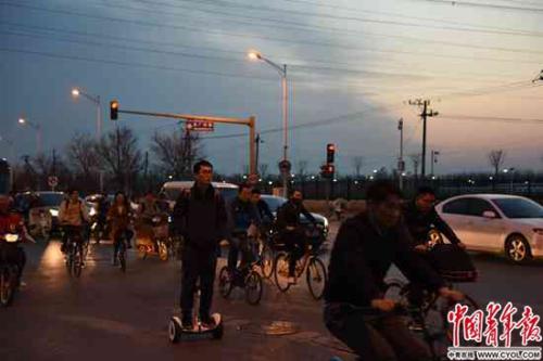 后厂村路路口，一名男子踩着电动平衡车过马路。据说这里以名字土和堵车闻名。实习生 杨子怡 摄