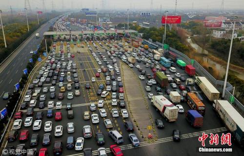资料图：某高速收费站附近排起了长龙。金汉昕 摄 图片来源：视觉中国