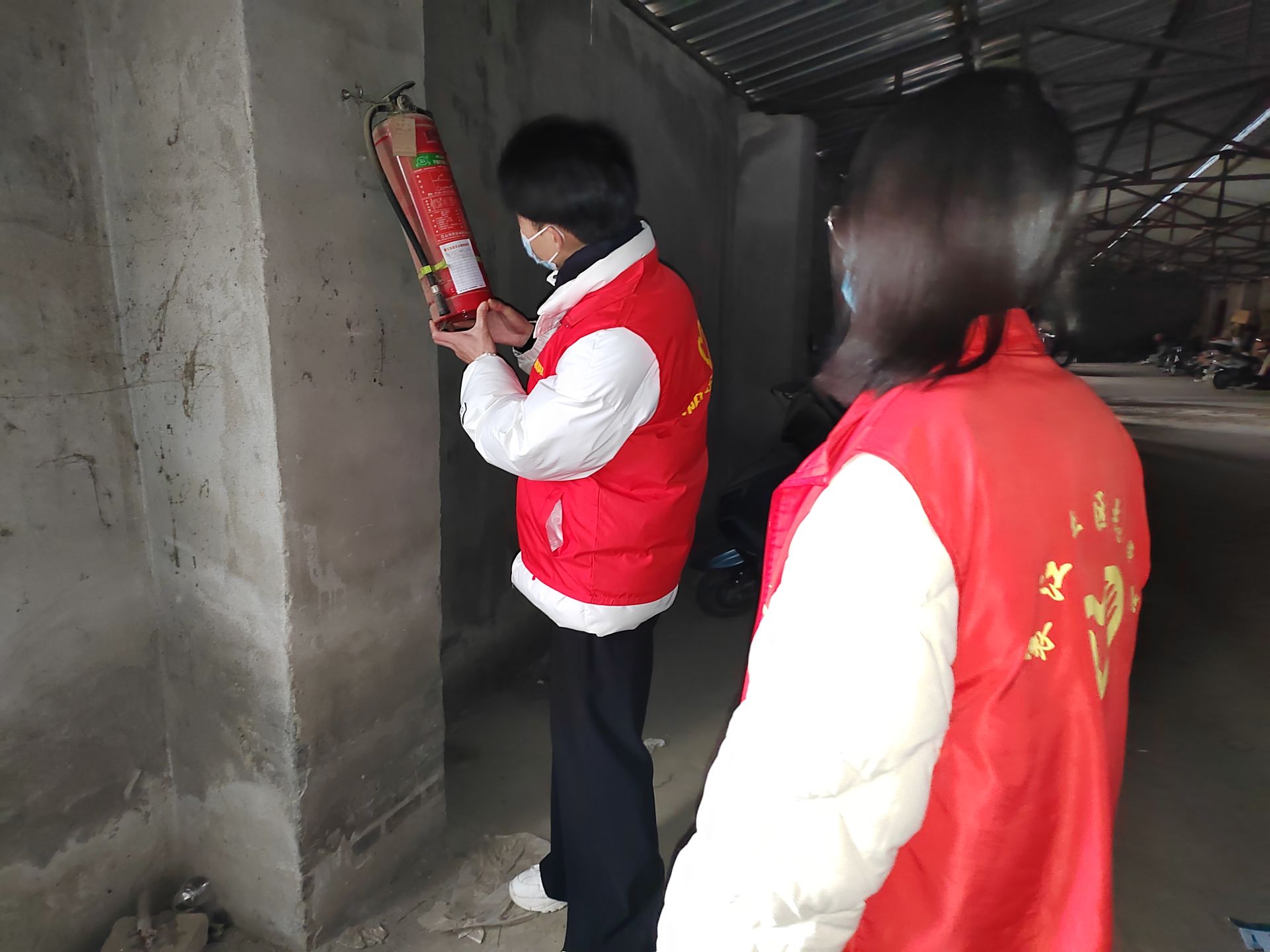 襄江社区的大学生志愿者为灭火器体检