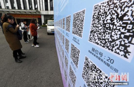 资料图：一些求职者在招聘会现场扫二维码查询工作岗位。 张斌 摄 (图文无关)