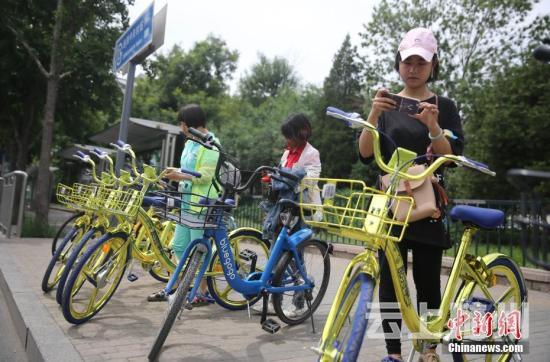 资料图 6月8日，民众在北京街头扫码租用一款“土豪金”色的共享单车。 <a target='_blank' href='http://www.chinanews.com/'>中新社</a>记者 杨可佳 摄