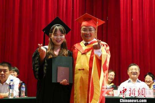 “比个小心心。”学生和院长玩起时下流行的“手动比心”。　钟欣 摄