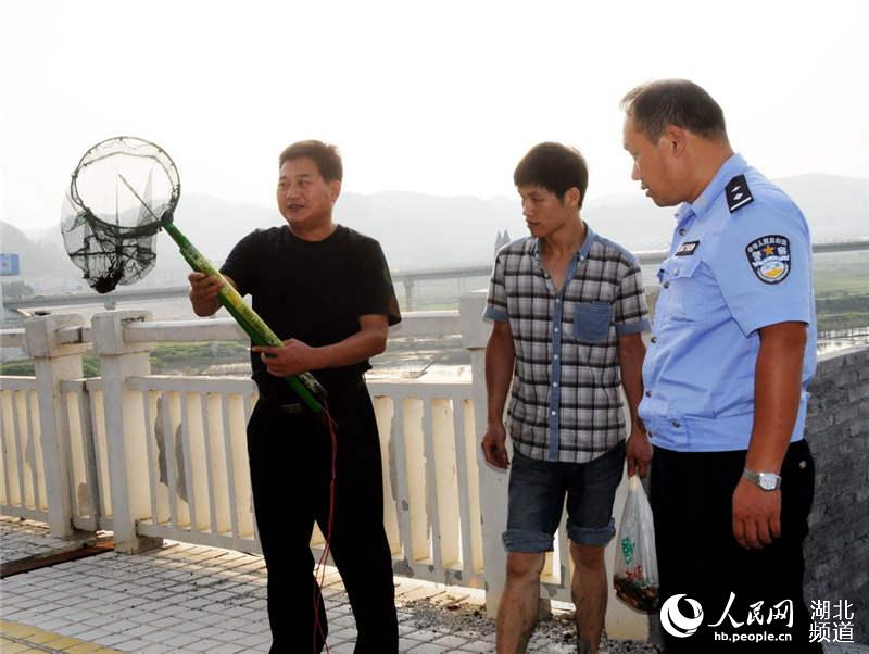 图为水上派出所收缴电鱼工具时的情景