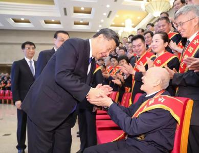 今天，张富清坐在了习近平总书记身边