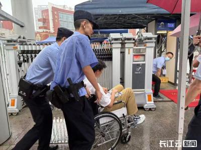 高考期间考生晕倒获及时援助 民警抬着轮椅护送考生进考场  
