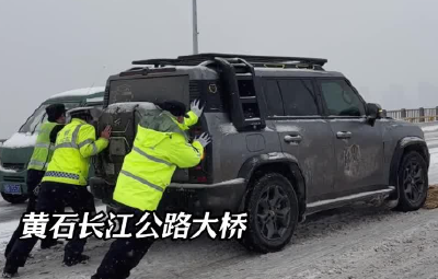 湖北黄石：雪天车辆打滑“趴窝”  交警奋力推车成雪中“风景”