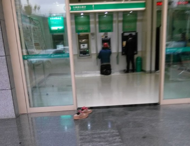 民工怕弄脏银行地面 脱鞋跪地取款