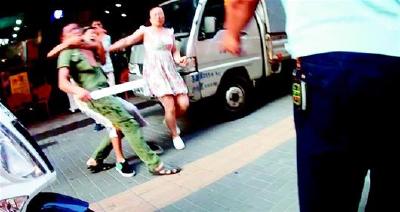 违停男子挥舞西瓜刀砍向交警 幸被其儿子死死拉住