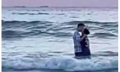 情侣站在海浪里拥吻 目击者：日出没看到 全看他们了