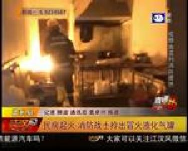 民房起火 消防战士拎出冒火液化气罐