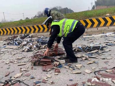 公路上瓦片散落一地，民警冒雨变身“搬运工”