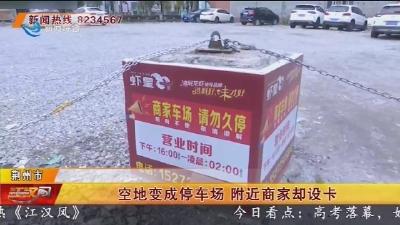 空地变成停车场 附近商家却设卡