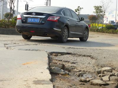 破损路面修复遭遇“寻主”尴尬 记者时隔近一月后调查仍无结果，市民急盼修复