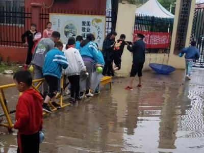 积水阻断上学路  老师搭起“简易桥”
