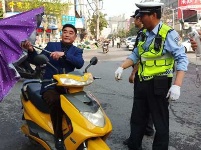 重拳出击 谷城交警严查拆除电动车安装遮阳篷