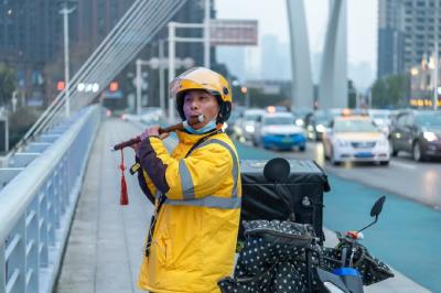 被拍照市民赞为“喧嚣里的一股清流” 武汉外卖小哥歌笛桥上吹笛子
