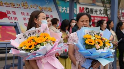 高考首日：家长穿旗袍 抱鲜花 祝考生旗开得胜