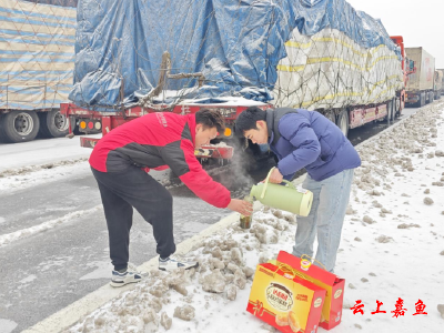 【防范应对新一轮低温雨雪冰冻天气】鱼岳镇群众为滞留货车司机送上暖心物资